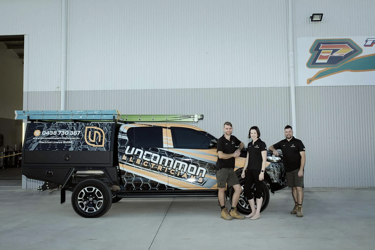 A group of Local people standing next to a Reliable truck in a garage.