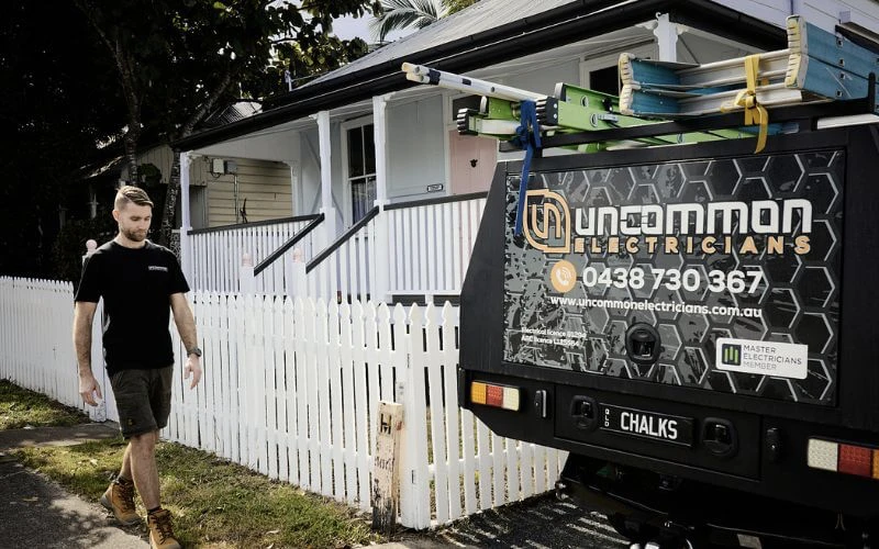A man standing in front of a truck with a sign on it advertising his home moving service.
